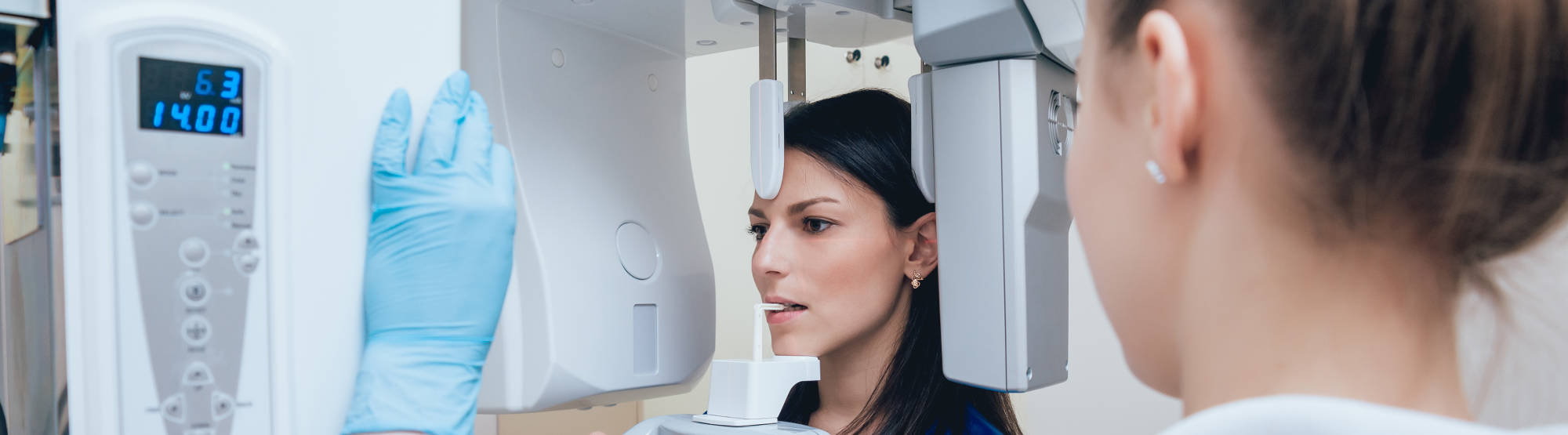 Young woman patient standing in x-ray machine. Panoramic radiography